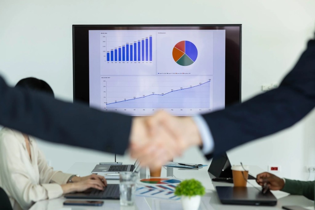Business handshake in front of a trade growth chart